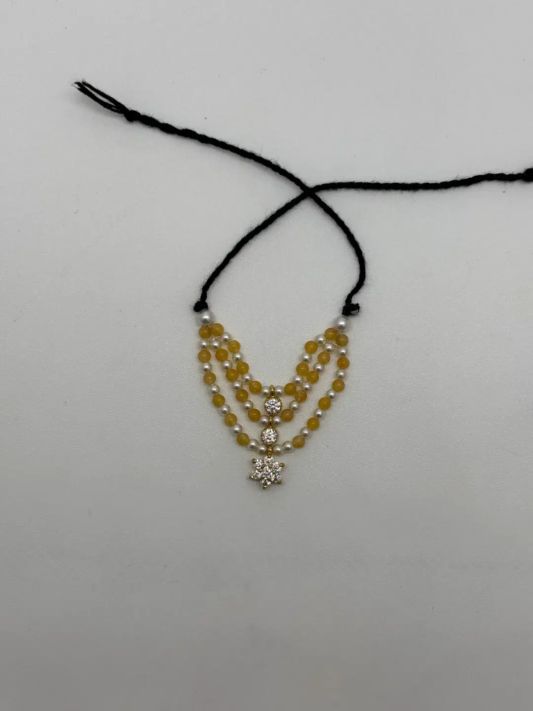 Three-tier yellow pukhraj and seed pearl mala with silver floral star AD pendant for size 1-2 Laddu Gopal