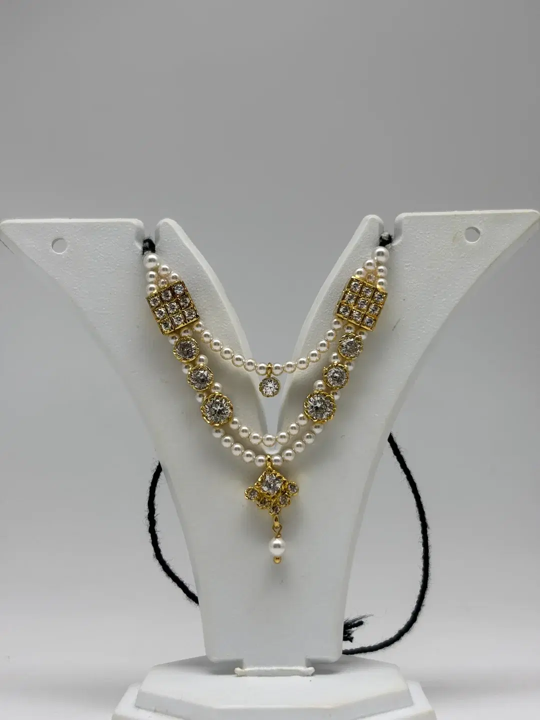 Double-strand pearl haar with silver rectangular AD chowkis and diamond-shaped pendant for Laddu Gopal